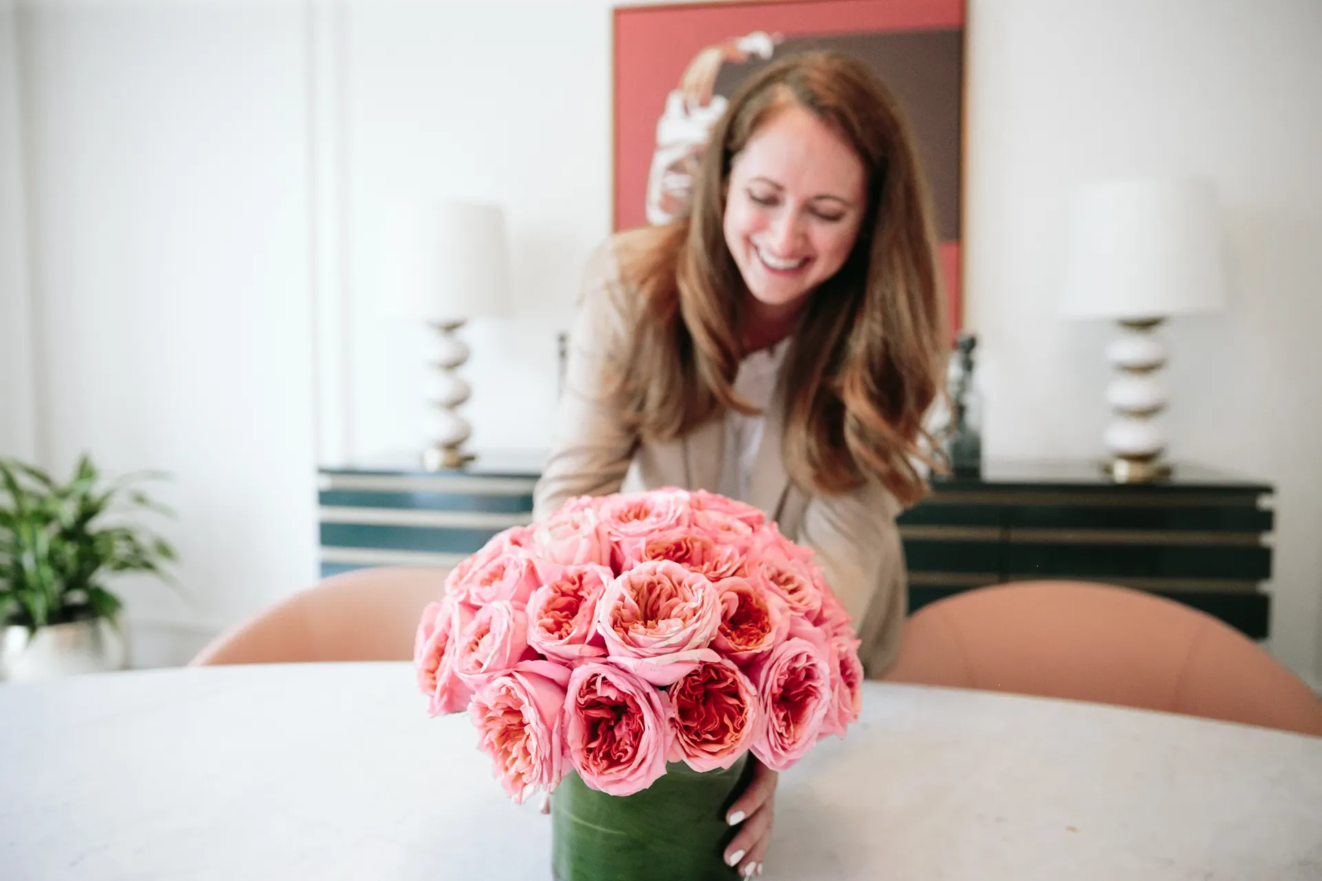 Anina Giannini smiling over a bouquet of pink garden roses