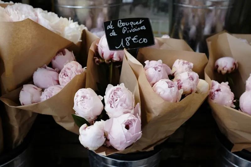Peonies wrapped in paper at a French flower market